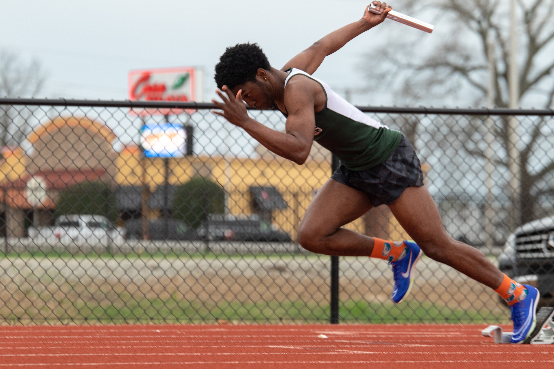 men's relay runner leaving the blocks
